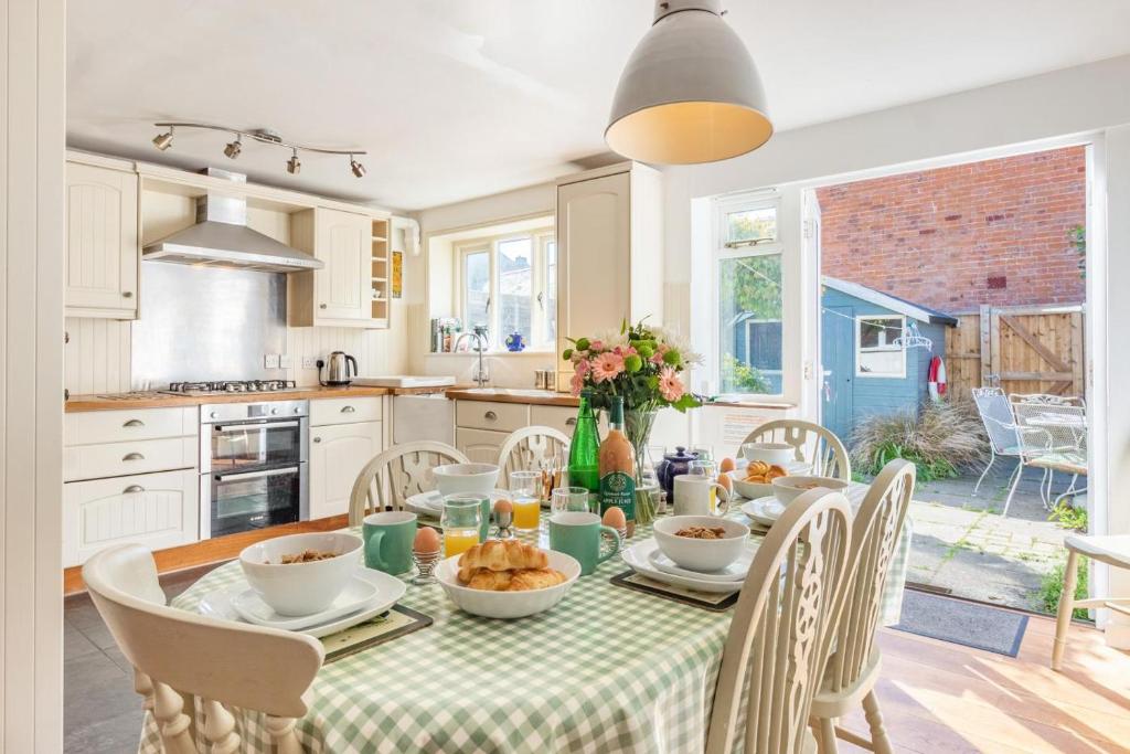 a dining room with a table and chairs and a kitchen at 3 Bed in Southwold oc-hsmugg in Southwold