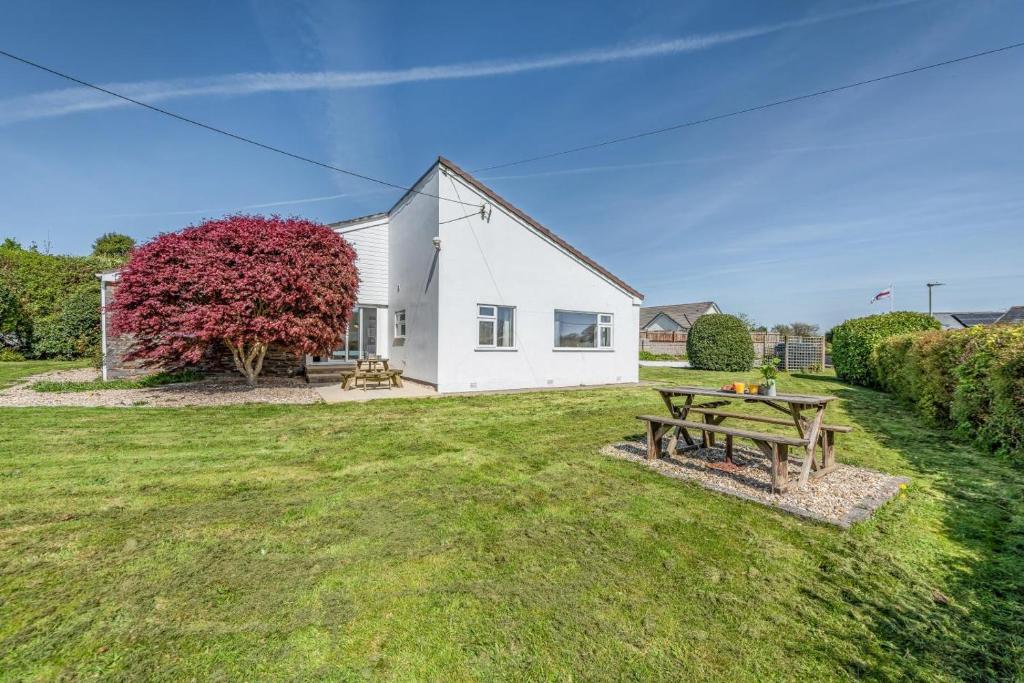 a white house with a picnic table in the yard at 4 Bed in Bideford oc-76452 in Parkham
