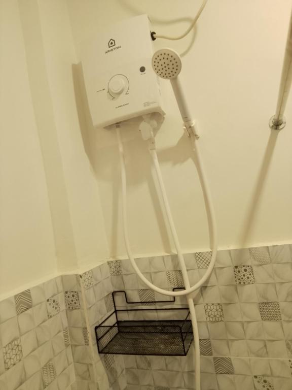 a shower with a hose in a bathroom at Axc cozy inn in Olongapo