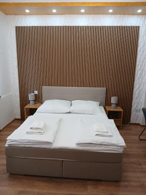 a bedroom with a bed with white sheets and two tables at Doppelbett Zimmer mit Boxspringbett in Weiden