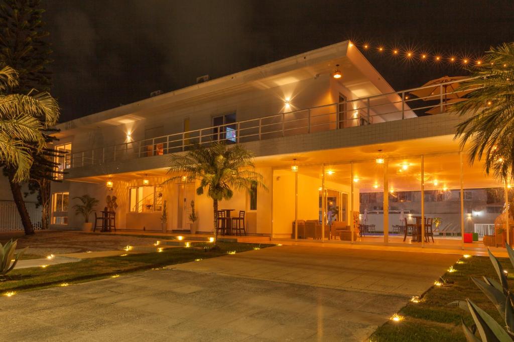 a large white building with a balcony at night at Almaê Pousada in Matinhos