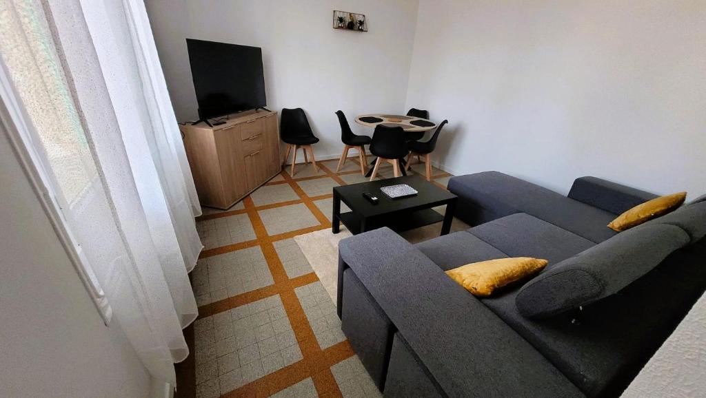 a living room with a couch and a tv at Gîte Champgrand in Loriol-sur-Drôme