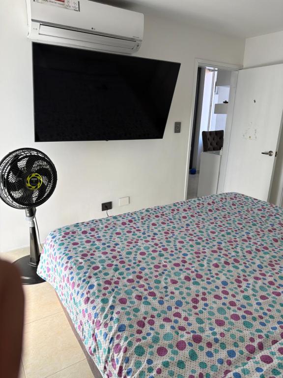 ein Schlafzimmer mit Bett und Flachbildfernseher in der Unterkunft Manhattan PH in Cúcuta