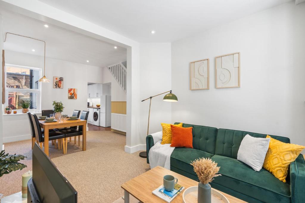 a living room with a green couch and a table at Spacious 2-Bed Eastbourne Retreat in Eastbourne