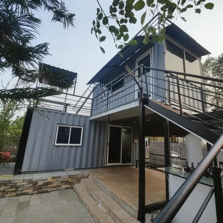 a house with a blue roof and a balcony at OrchardNest in Moinabad