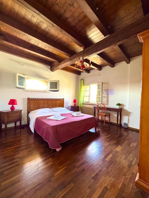 a bedroom with a large bed with a red blanket at A 5 min da Bassano Camera con Bagno Privato e Area Fitness in Bassano del Grappa