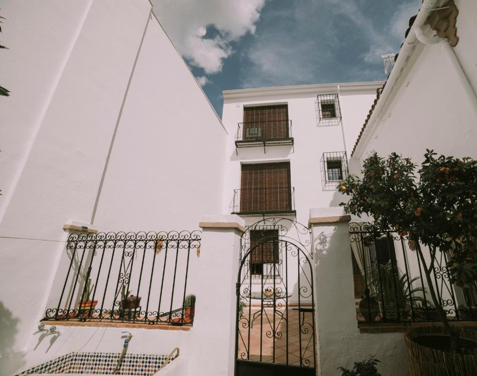 a white building with balconies and a fence at Casa Aula Minerva Sapientia 2 Habitaciones in Almedinilla
