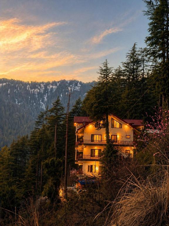 a building on the side of a mountain at sunset at Noon Villa in Kanethi