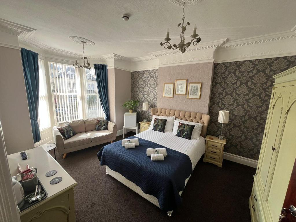 a bedroom with a bed and a couch at The Westbourne Guest House in Llandudno
