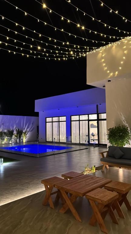 a room with a table and benches and lights at منتجع دار DAR Resort in Hail