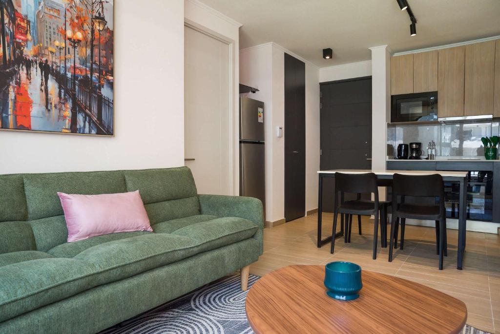 a living room with a green couch and a table at Chic Providencia Apt 2BR 2BA Sleeps 5 in Santiago