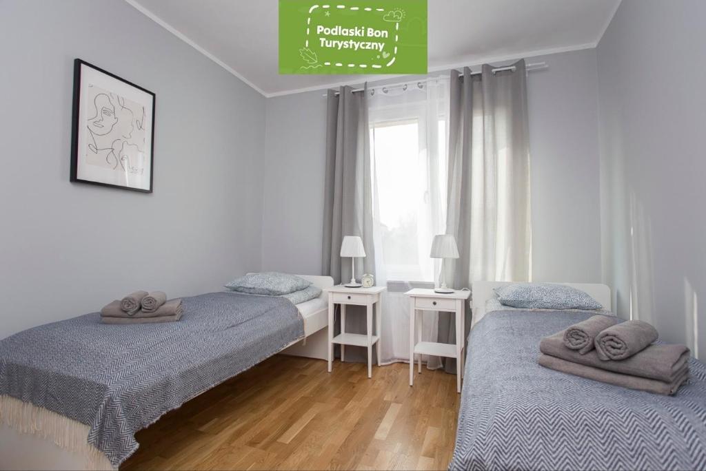 a bedroom with two beds and a window at CR Apartament Centrum Zamenhofa 1 in Białystok