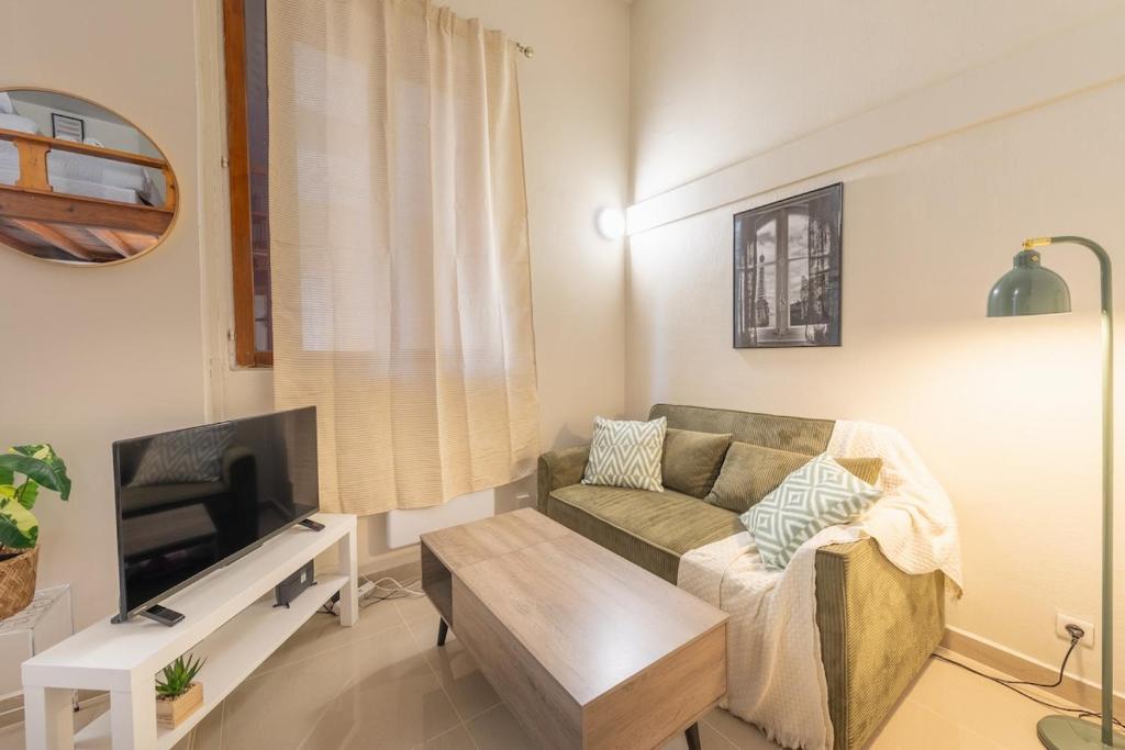 a living room with a couch and a tv at Urban Nest in Sevran