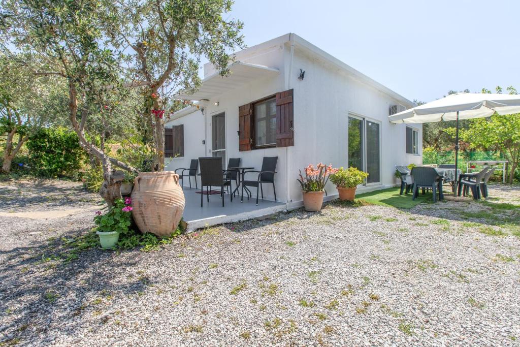 a white house with a table and chairs at Stella's Olive Tree House in Adelianos Kampos