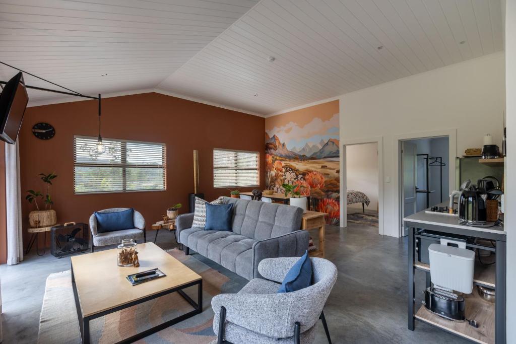 a living room with a couch and a table at Cape Dutch Stay, Suite A in Sedgefield