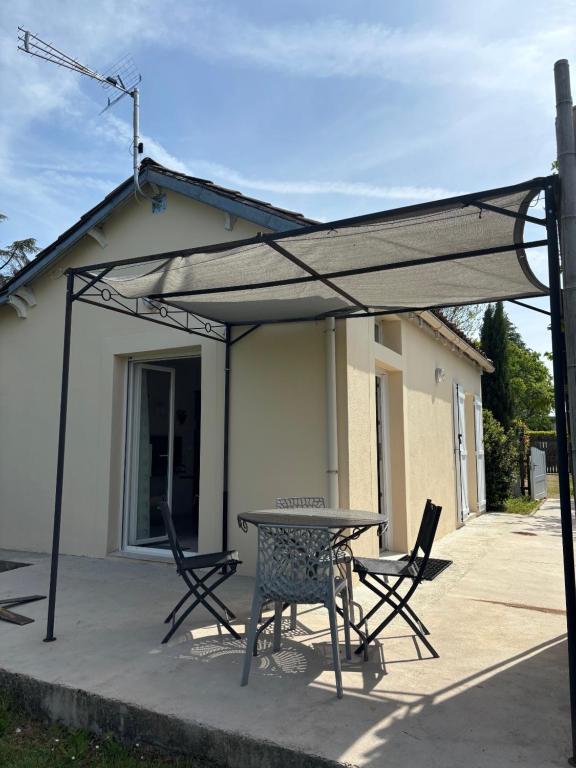 a patio with a table and chairs under a canopy at Maison Ustou46 in Cahors