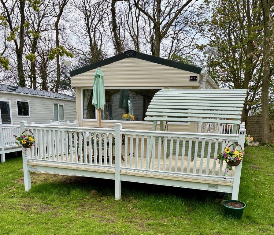a white house with a porch and an umbrella at Sunflower Retreat in Cresswell