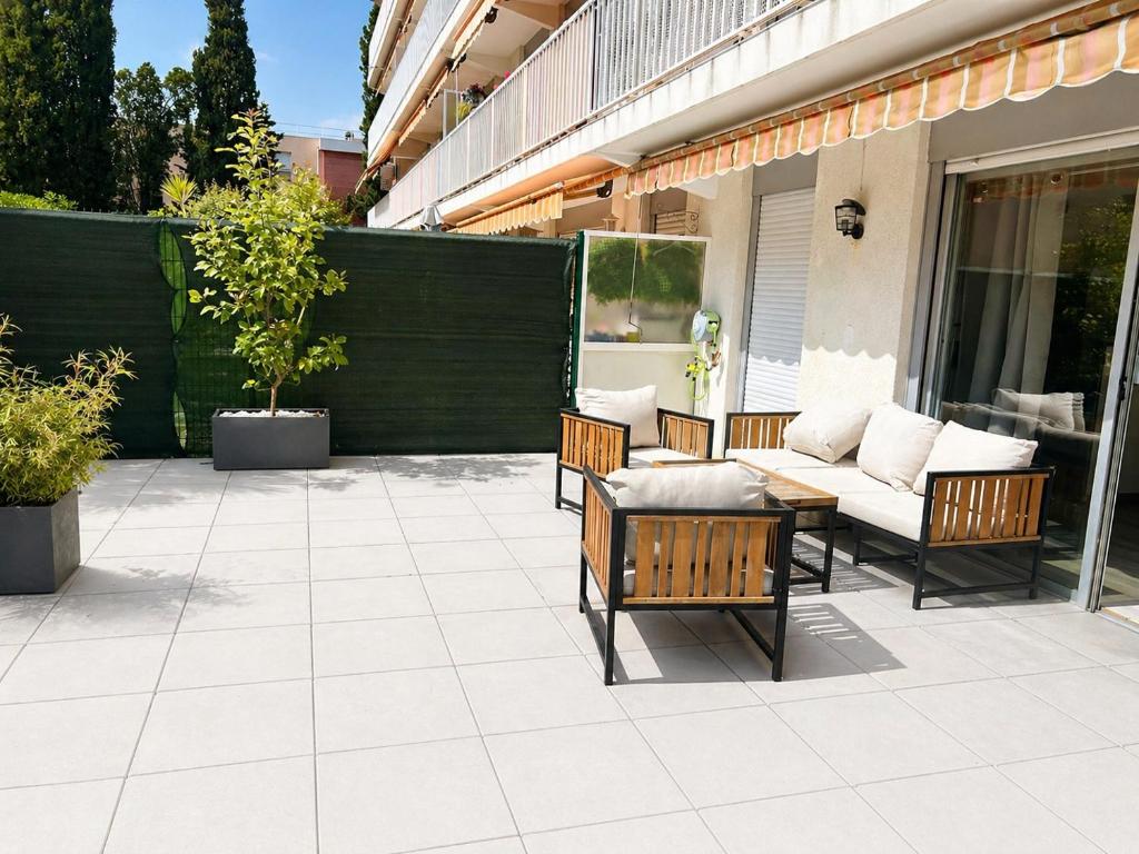 a patio with chairs and a table and a couch at L'échappée Méditerrannée in Vallauris
