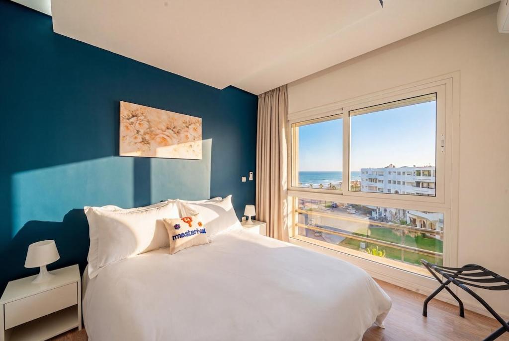 a bedroom with a large bed and a large window at Ocean Breeze 2BR Ocean View Rabat Corniche in Rabat