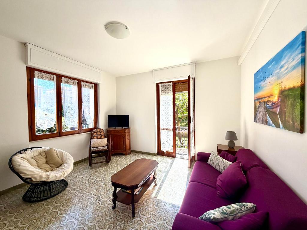 a living room with a purple couch and a table at Francesca Appartamento con giardino in Levanto