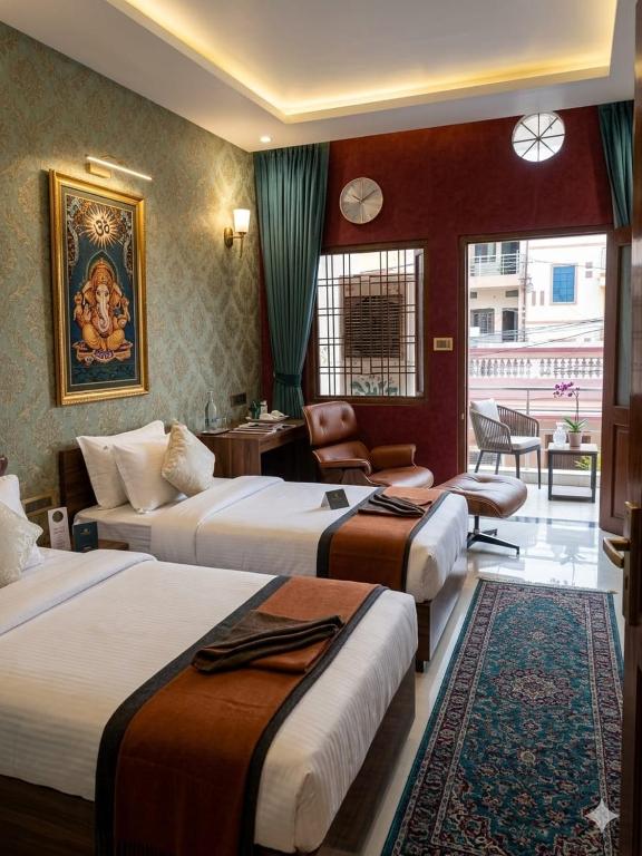 a hotel room with three beds and a chair at Narmada Gest House in Indore