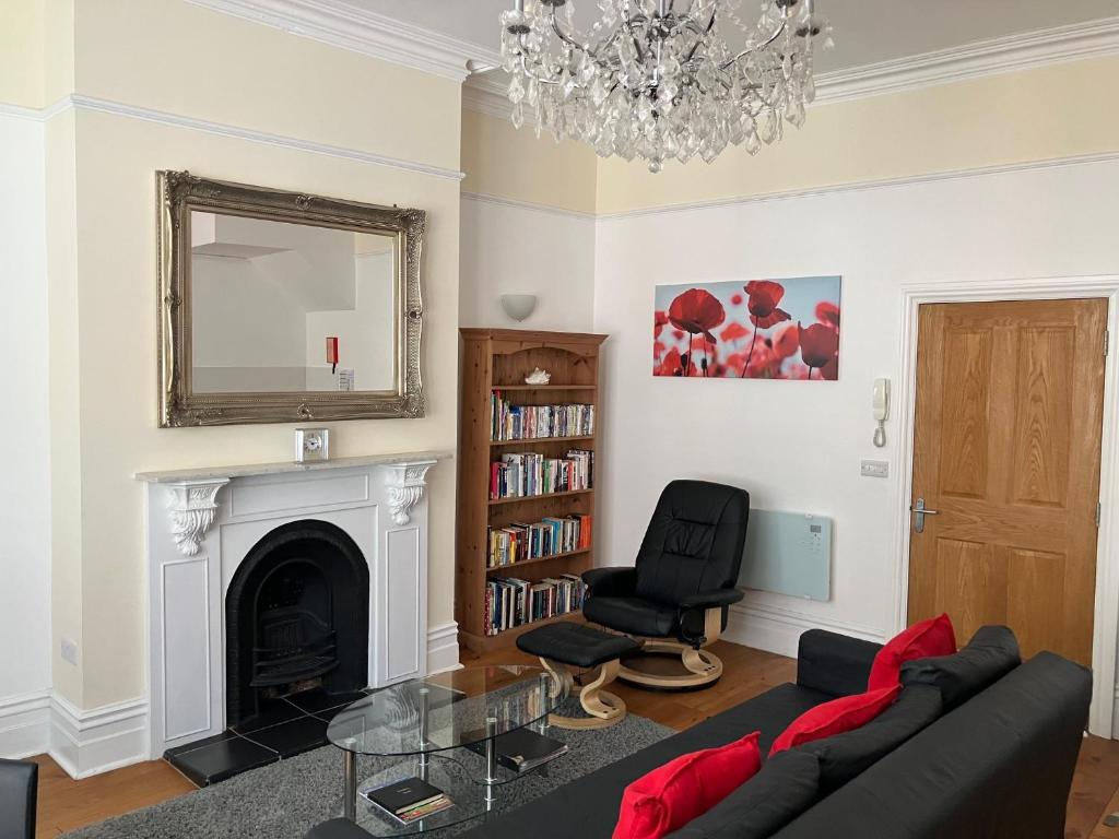 a living room with a couch and a fireplace at High Street Suites 3 in Ventnor