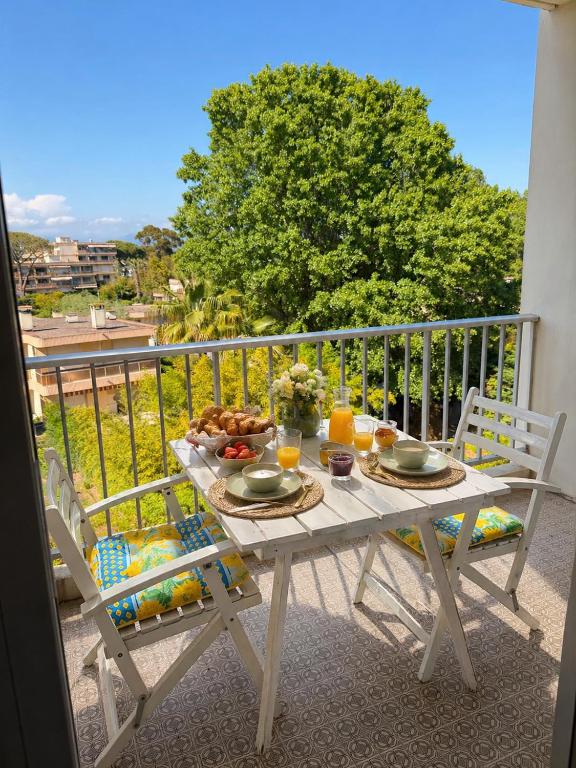 a table with food and drinks on a balcony at Azur Couple Studio in Mandelieu-La Napoule