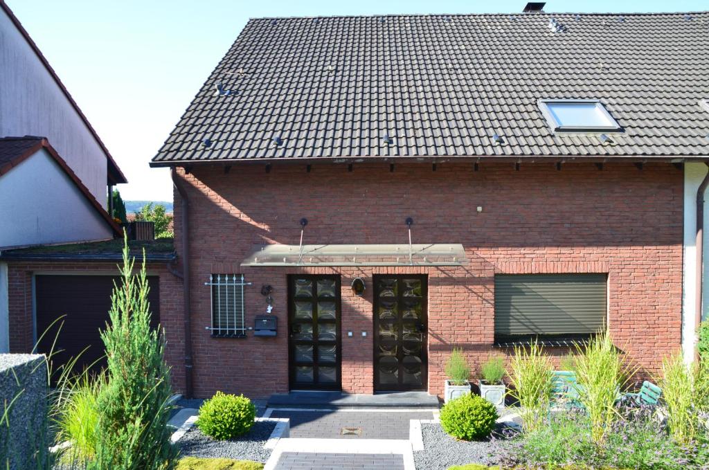 une maison en briques rouges avec une porte noire dans l'établissement Ferienwohnung Blankenstein, à Hattingen