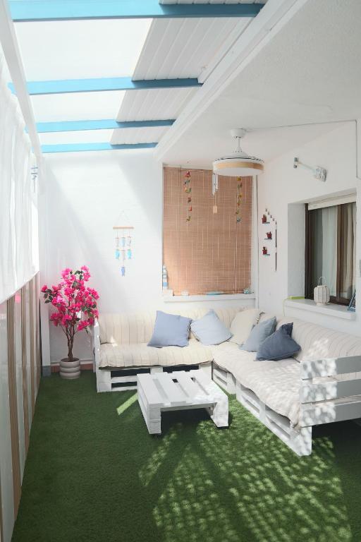 ein Wohnzimmer mit weißen Möbeln und einem grünen Teppich in der Unterkunft Darahome in Cunit