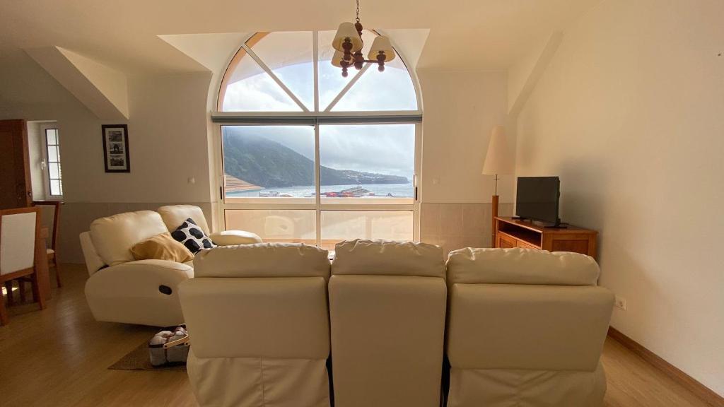 a living room with a couch and a large window at Alojamento Local Velas Balcony in Velas