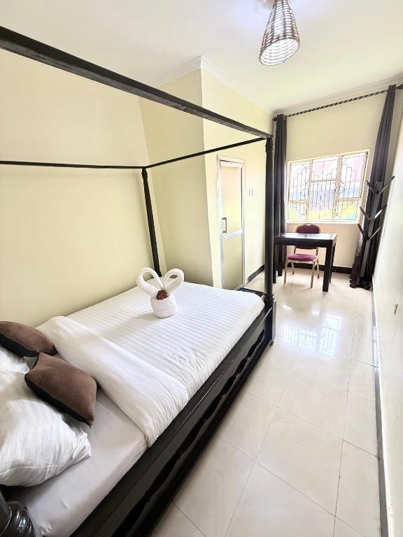a bedroom with a bed with a white bowl on it at Cajanus Inn & Safaris in Karatu