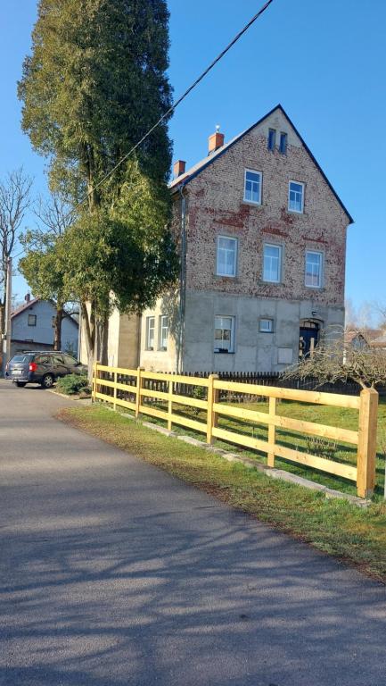 a wooden fence in front of a house at Apartmány LENKA in Mikulášovice