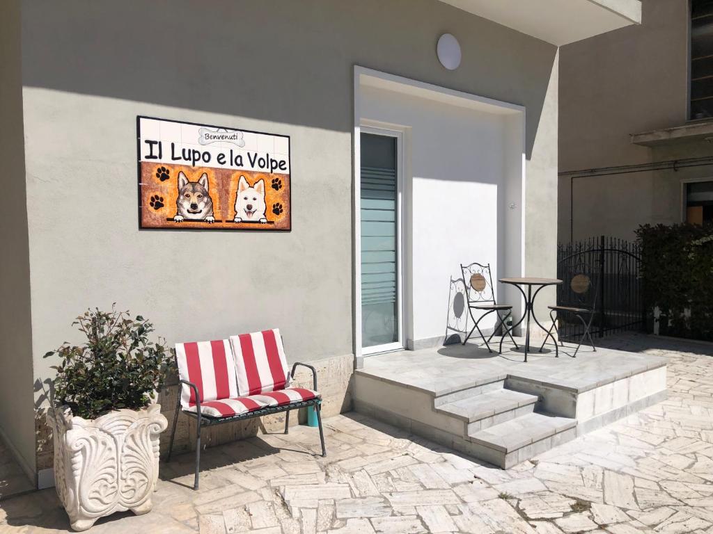 a porch with a chair and a sign on a house at La Tana de Il Lupo e La Volpe in Centobuchi