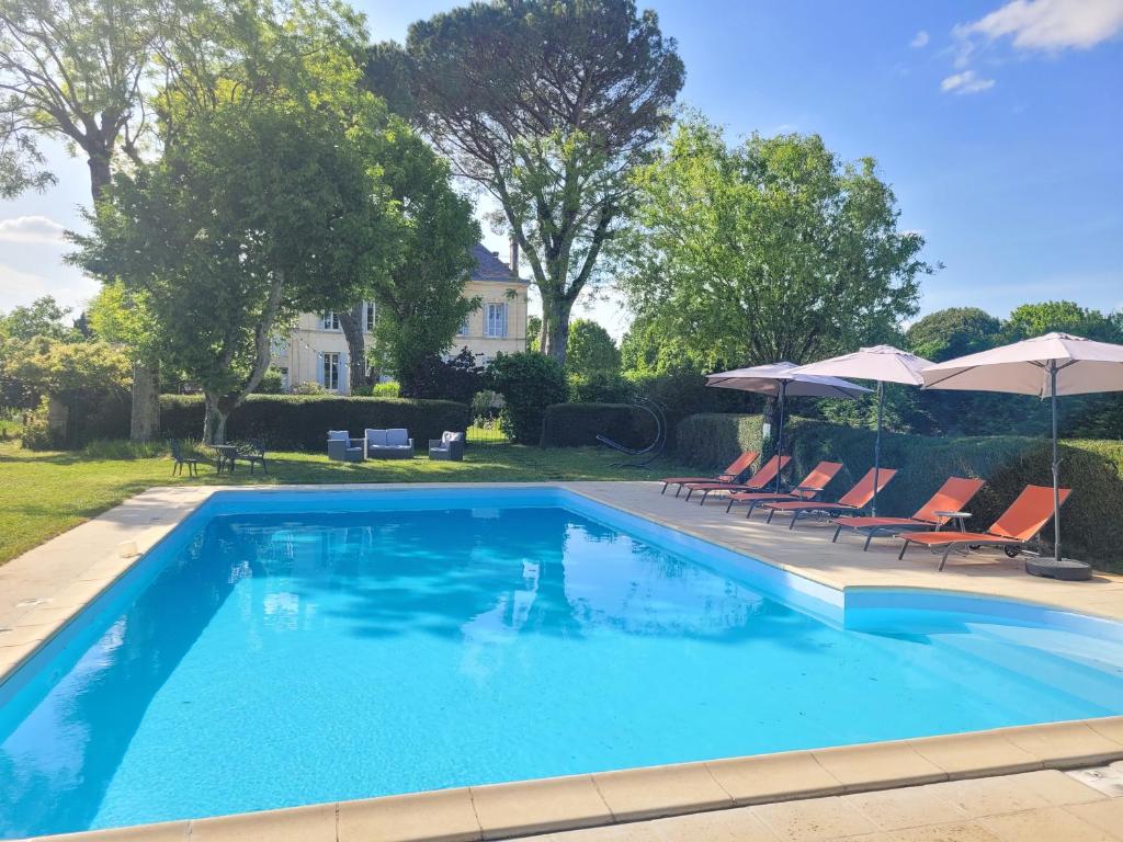 a large swimming pool with chairs and umbrellas at Le Logis d'Epargnes B&B and Gite in Épargnes
