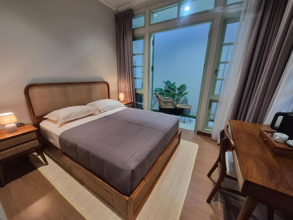 a bedroom with a bed and a large window at Dalem Kamulyan Kraton in Timuran