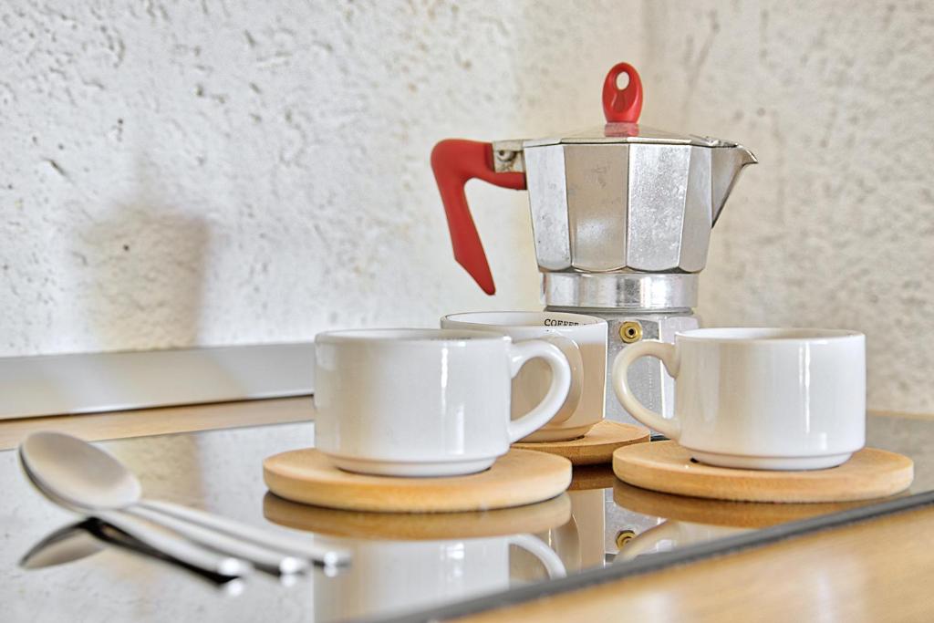 two coffee cups on a counter with a juicer at Monolocale al centro della Costa Smeralda in Cugnana Verde