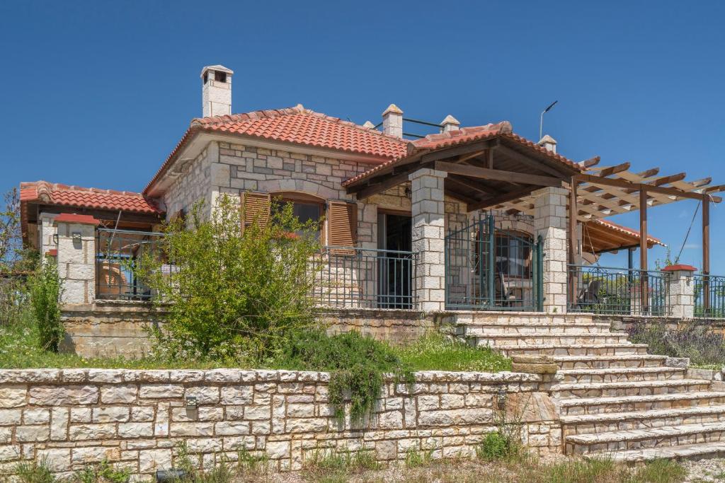 a house with a stone staircase in front of it at Polilimnio Foteini's Mini Castle in Metamórfosis