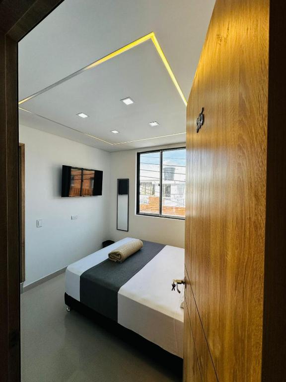 a bedroom with a bed and a window at Aero Hotel in Bogotá