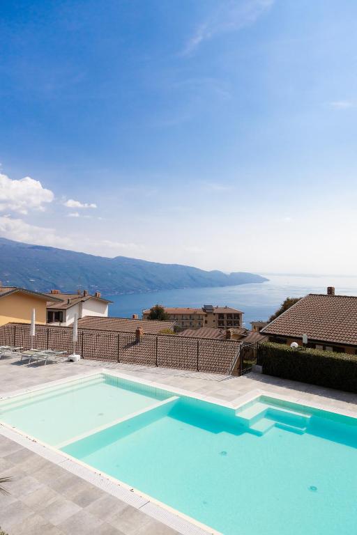 a large swimming pool with a view of the water at Residence Primera Rompala, GTSGroup in Tignale