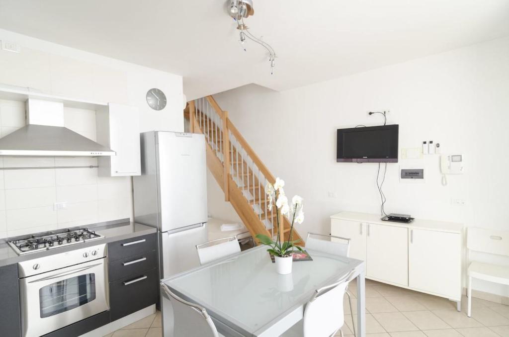a kitchen with white cabinets and a stove top oven at Appartamenti Federica 5 in Milano Marittima