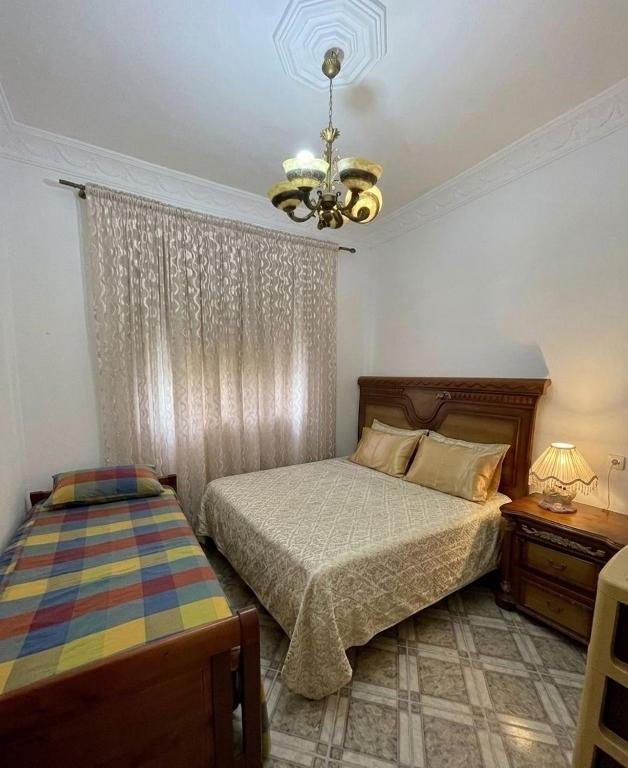 a bedroom with a bed and a chandelier at Central Private Haven in Martil