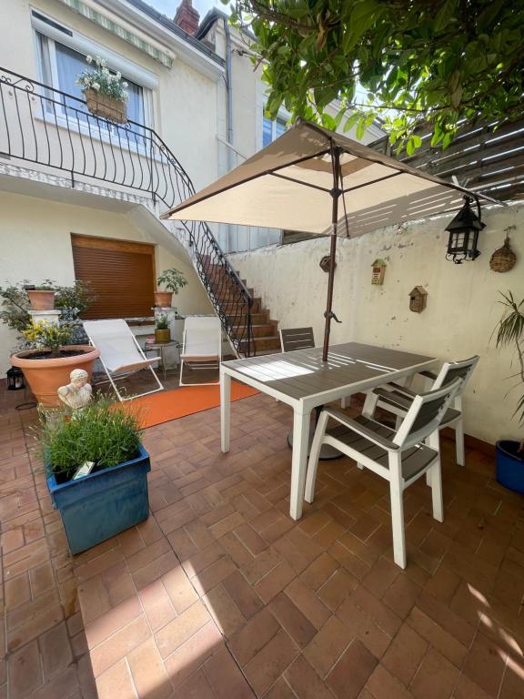 a table and chairs with an umbrella on a patio at Champoiseau in Tours