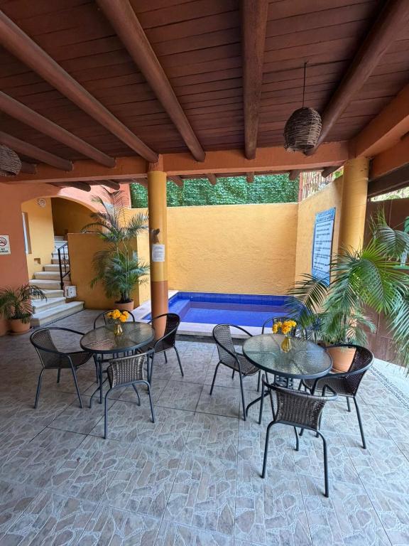 a patio with tables and chairs and a pool at Hotel Las Salinas in Zihuatanejo