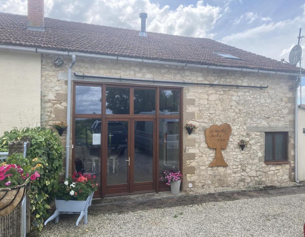 a small stone building with a wooden door at Le Chene Vert in Millac