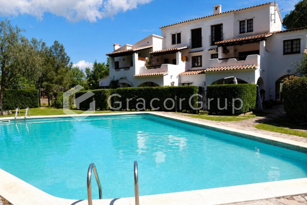 a villa with a swimming pool in front of a house at Casa El Trebol in L'Escala