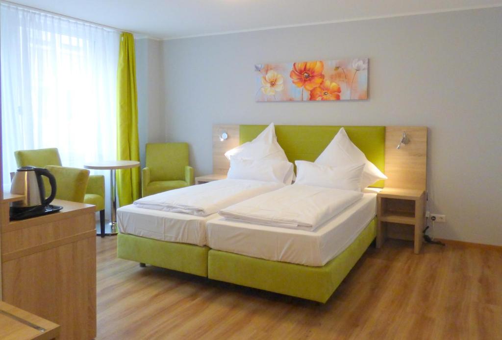 
a bedroom with a bed, a desk, and a lamp at Minx – CityHotels in Aachen
