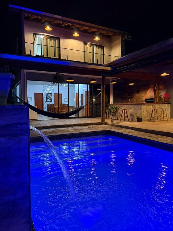 a house with a swimming pool at night at Recanto Feitosa Taubate in Taubaté