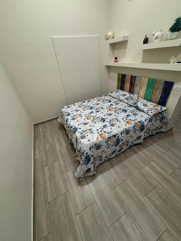 a bedroom with a bed with a floral comforter at MareLuna in Torre del Greco