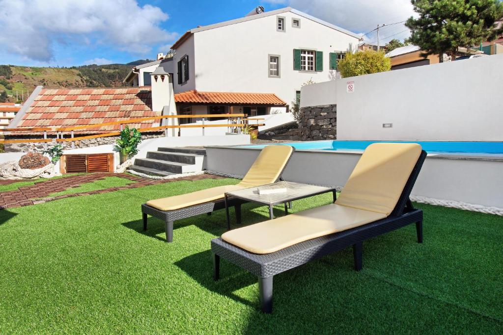 two chairs and a table on a lawn at Casa Carreira in Ponta do Sol
