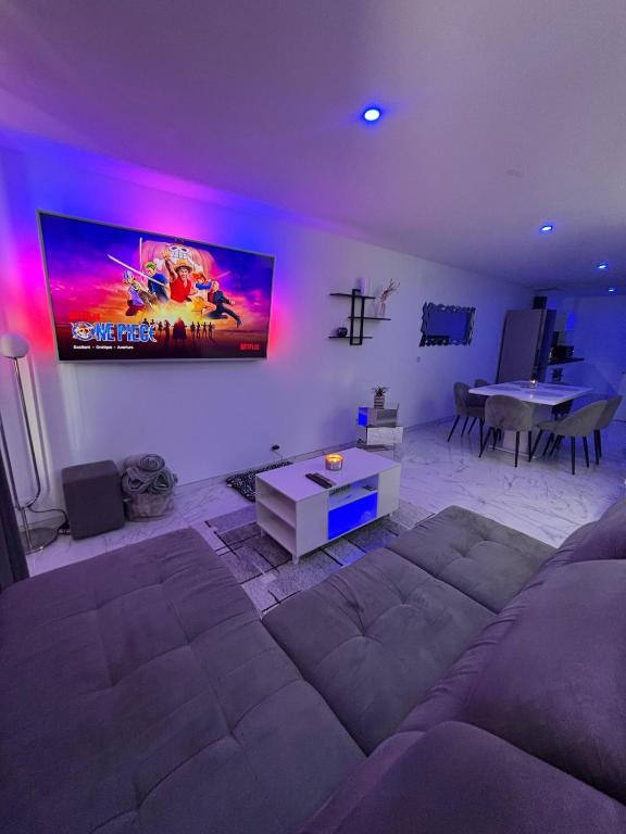 a living room with a couch and a tv on the wall at Le 21 Comfortable townhouse in Morhange